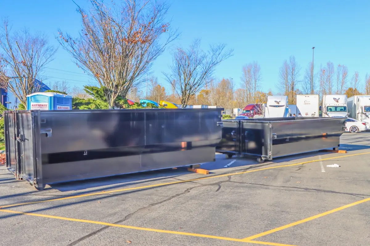 Professional dumpster rental service with roll-off container on residential driveway in Ramsey